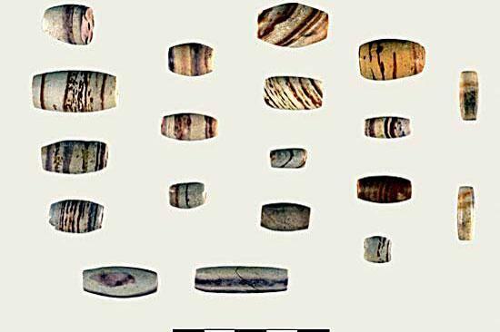 Banded sandstone beads and (bottom row) imitation stone beads made of different colors of clay.