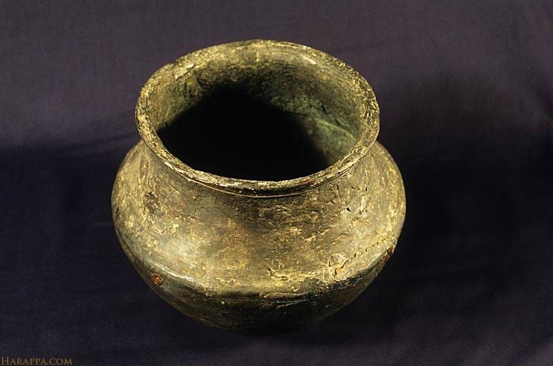 This metal vessel is almost identical to many terra cotta cooking vessels and was probably intended for a very wealthy family. It was made by hammering a sheet of copper and raising the hollow base and rim separately. The two pieces were joined together with cold hammering at the ledge. This vessel contained a hoard of copper weapons and tools.