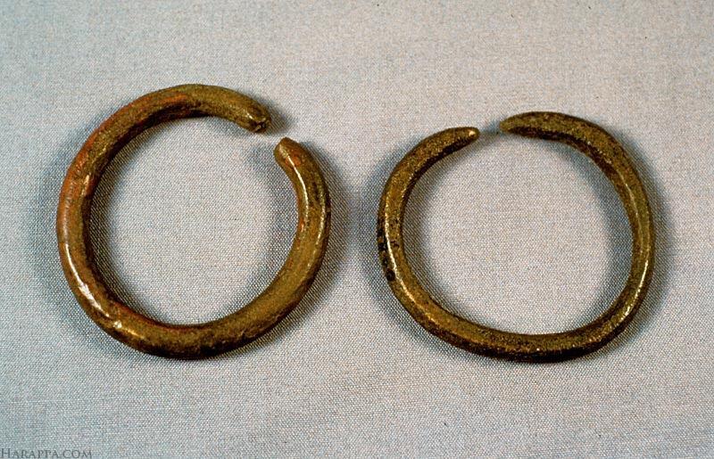 The bangles were made from a round hammered rod bent in a full circle. The space between the ends of the bangle would be pried apart to slip it over the wrist.