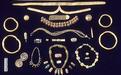 This collection of gold and agate ornaments includes objects found at both Mohenjo-daro and Harappa. At the top are fillets of hammered gold that would have been worn around the forehead.  The other ornaments include bangles, chokers, long pendant necklaces, rings, earrings, conical hair ornaments, and broaches. Such ornaments were never buried with the dead, but were passed on from one generation to the next. These ornaments were hidden under the floors in the homes of wealthy merchants or goldsmiths.