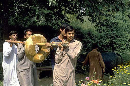 Laboratory assistants Mohammad Naim, Shokat Ali, Said Ahmed, and Mukthar Massih carry the cleaned and conserved ringstone to the Harappa Museum for display.