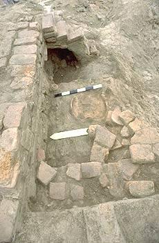 A small pot was found on the floor just to the west of the large globular vessel (the big hole in the wall is where it once sat). In the foreground are other large jars set into the floor and used as hearths or garbage pits. Trench 38, Late Harappan Period ( ca. 1900 - < 1300? BCE).