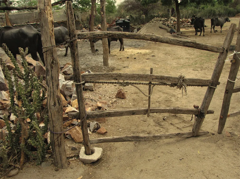 Stone mortar that has been repurposed as a pivot for a wooden gate