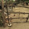 Stone mortar that has been repurposed as a pivot for a wooden gate